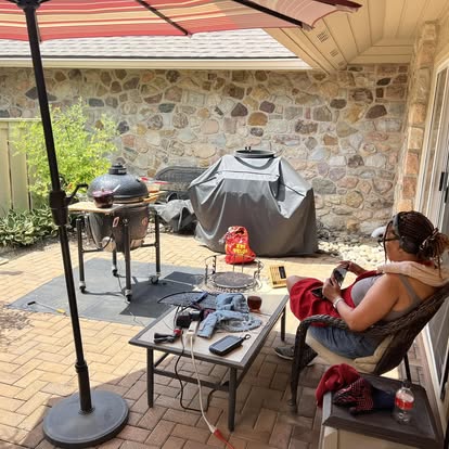Darla Wolfe relaxing beside her backyard smokers