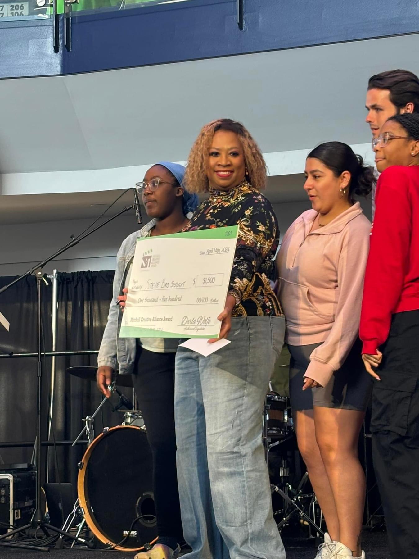 Darla Wolfe presenting the winning Mitchell Creative Alliance Award check to student filmmakers